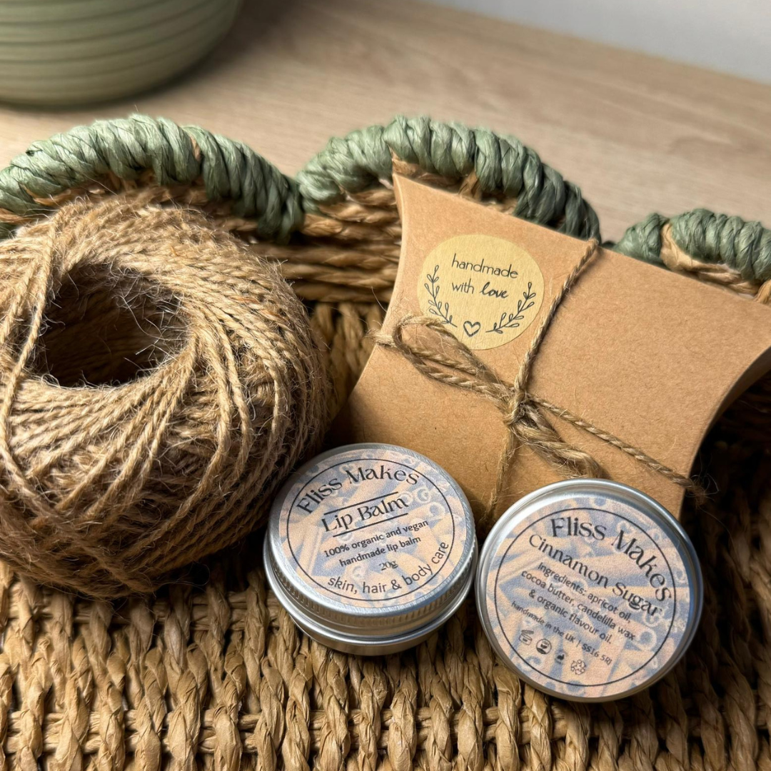 Two tins of of 100% natural handcrafted cinnamon sugar lip balm made with organic, vegan and cruelty-free ingredients, showcasing its smooth texture.