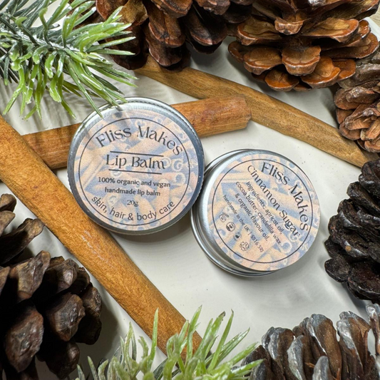 Two tins of of 100% natural handcrafted limited edition cinnamon sugar lip balm made with organic, vegan and cruelty-free ingredients, showcasing its smooth texture.