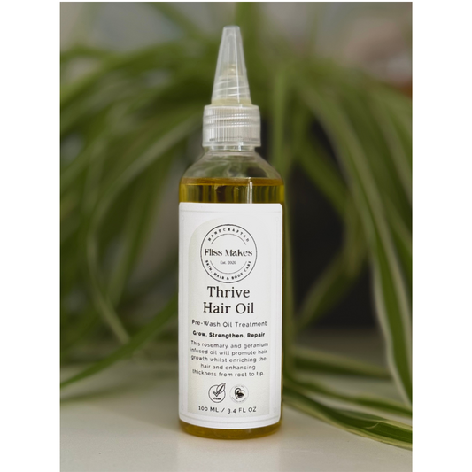 Bottle of 100% natural Thrive Hair Oil for thickening and hair growth made with organic, vegan and cruelty-free ingredients, showcasing its smooth texture.  